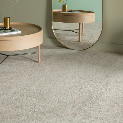 Balta Classic Charm carpet in Heathers (beige), featured in a stylish room with a minimalist table, a sleek mirror, and soft natural lighting, creating a warm and elegant atmosphere.