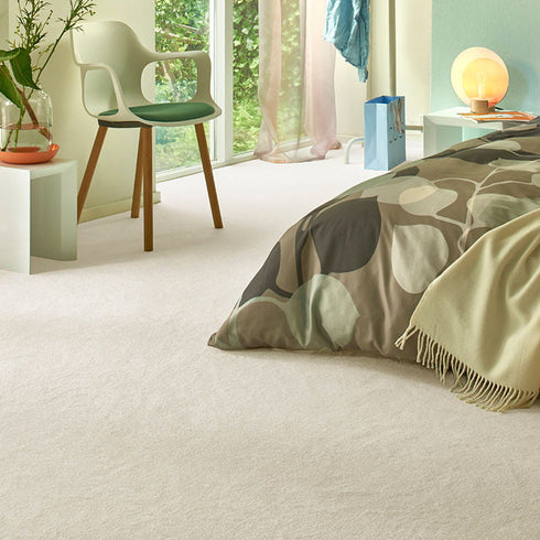 Sedna® Kai carpet in a warm cream shade, adding a soft, luxurious feel to a modern bedroom.