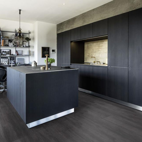 Kährs Schwarzwald luxury vinyl flooring showcasing a deep charcoal tone with subtle wood grain accents, adding a touch of modern sophistication.