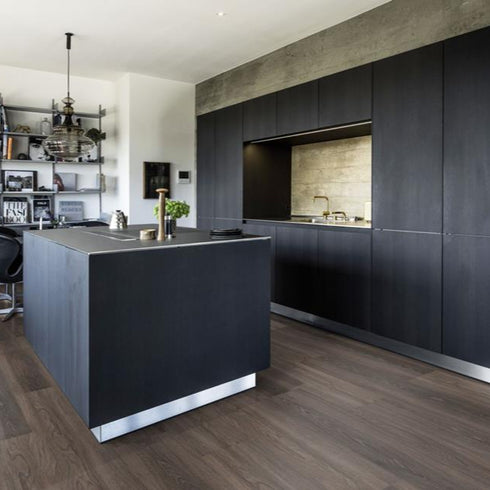 Kährs Tongass luxury vinyl flooring displaying a rich walnut tone with dynamic grain patterns, perfect for creating a warm and inviting environment.