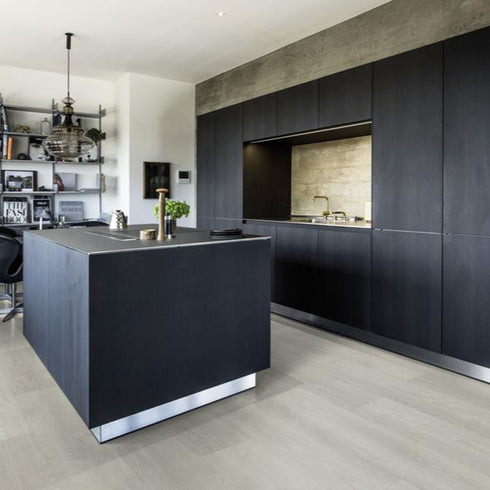 Kährs Yukon luxury vinyl flooring presenting a light grey wood tone with understated grain details, suitable for modern and industrial-style interiors.