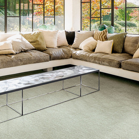 Sedna® Oshun carpet in Green Stone, a light olive shade, adding a natural and calming ambiance to a modern living room.