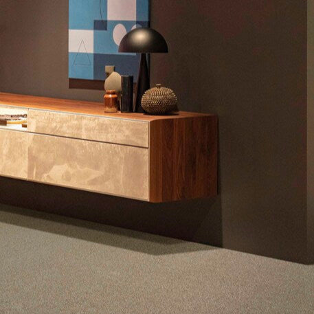 Lano Romance carpet in Cornstalk (a warm brown-beige), elegantly placed beneath a floating cabinet in a modern, minimalist room, highlighting its soft texture and sophisticated design.