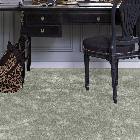 iSENSE® Surprise carpet in a rich olive green shade, complementing a classic room with a vintage-style chair and desk, creating a timeless and elegant atmosphere.