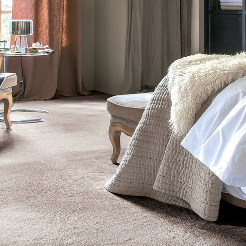 iSENSE® Surprise carpet in a warm beige tone, adding a soft and inviting touch to a cozy bedroom setting.