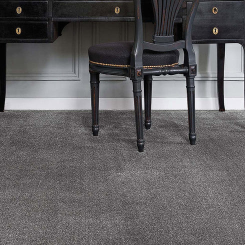 iSENSE® Surprise carpet in a cement grey tone, complementing a classic, stylish room with a vintage desk and chair.