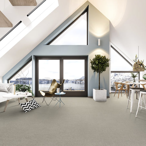 Lano Sweet Elegance carpet in Flax (beige), beautifully fitted in a spacious lofted apartment with large windows overlooking the water, enhancing the serene and sophisticated ambiance.