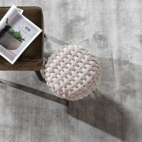 ITC Essence carpet in grey, complementing a simple and sophisticated room with a serene ambiance, featuring a book resting on a seat.