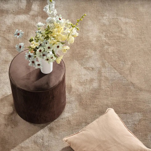 ITC Monza carpet in beige, showcasing its plush texture in a minimalist living room with a harmonious, thoughtfully designed interior.