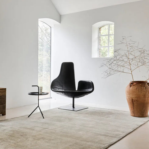 ITC Essence rug in beige, adding a touch of refined luxury to a sophisticated living space with minimal design and bright, airy tones.